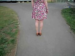 De vrouw pronkt met haar mooie zomerjurk op straat
