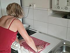 Зрела маћеха са великим сисама и длакавом вагином се прља у кухињи
