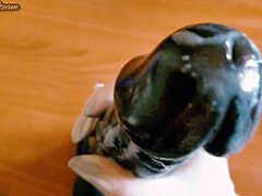 Amatör onanerar en stor svart dildo i varm närbild